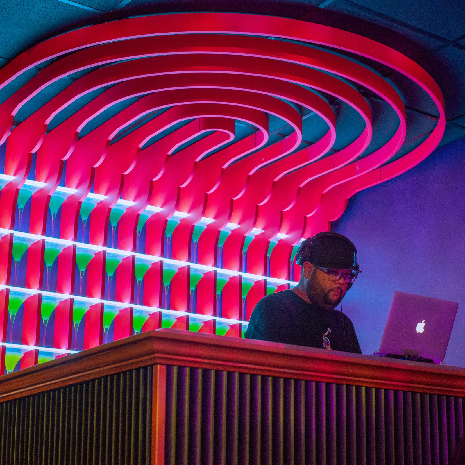 A DJ beneath the curved neon ceiling at Lola’s Liquors
