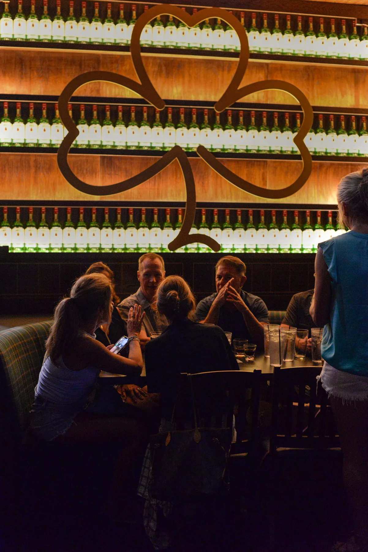 Guests seated beneath the illuminated shamrock at Murphy’s Law