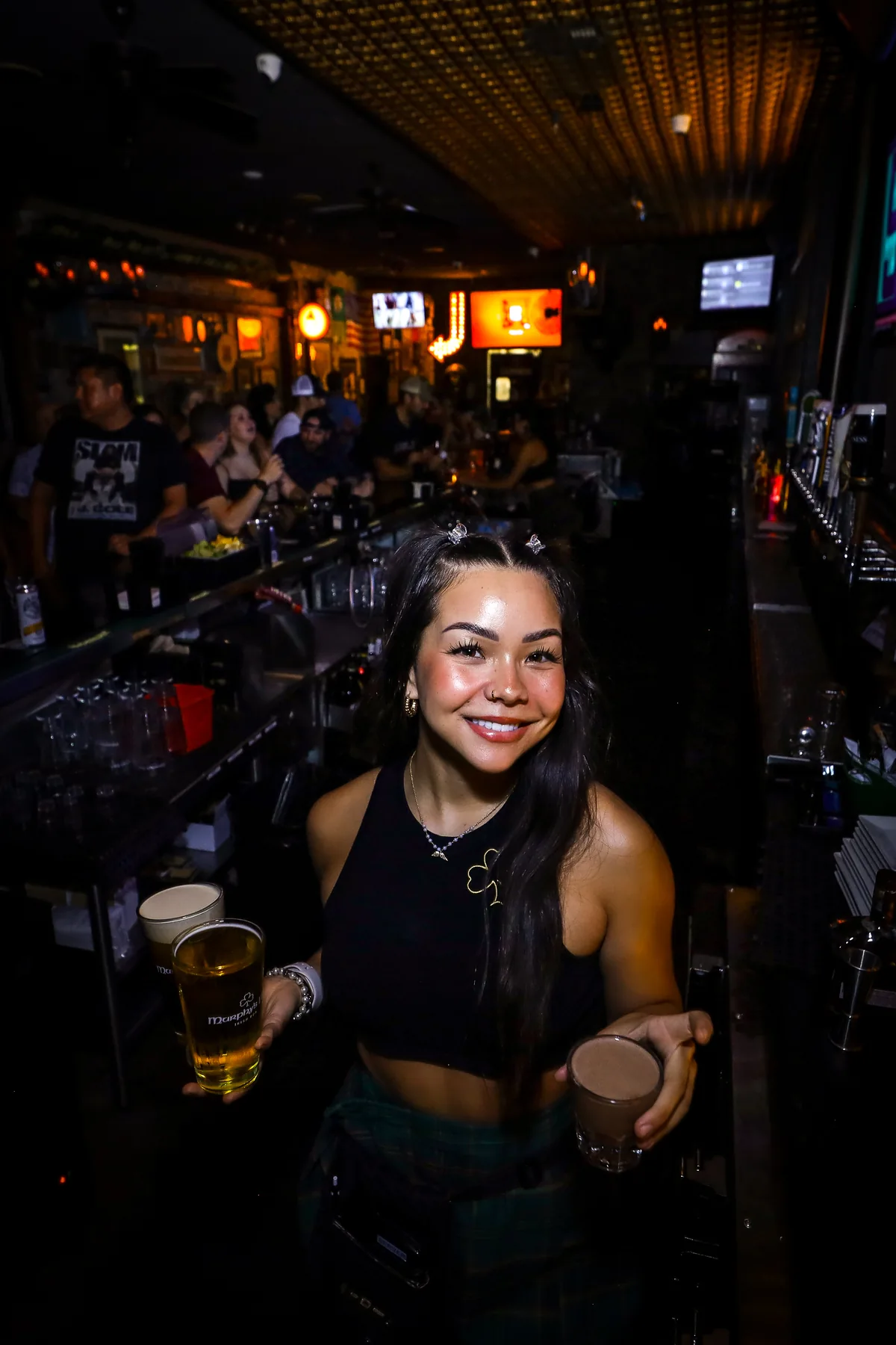 A smiling bartender with two pints at Murphy’s Law
